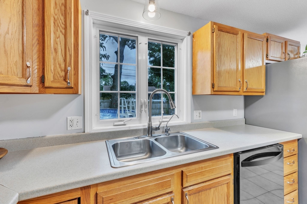 44 Border Street Springfield, MA 01104 - Photo 14 of 37 a kitchen with stainless steel appliances granite countertop a sink a window and cabinets