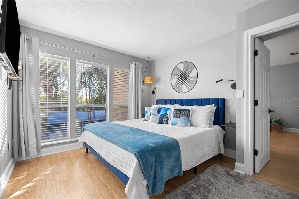 3443 Clark Road, Unit 242 Sarasota, FL 34231 - Photo 12 of 21 a bedroom with a large bed and a flat tv screen on dresser