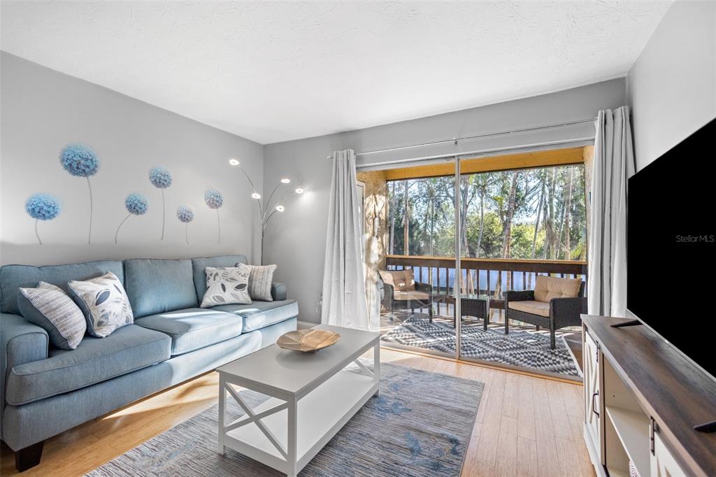 3443 Clark Road, Unit 242 Sarasota, FL 34231 - Photo 2 of 21 a living room with furniture and a flat screen tv