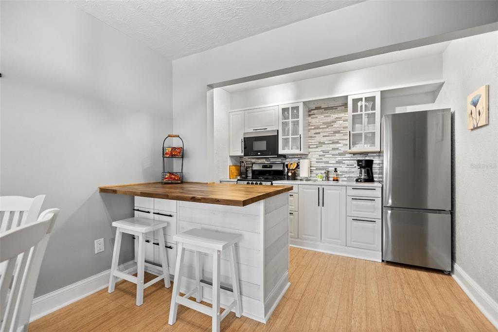 3443 Clark Road, Unit 242 Sarasota, FL 34231 - Photo 5 of 21 a kitchen with granite countertop a refrigerator stove top oven and sink