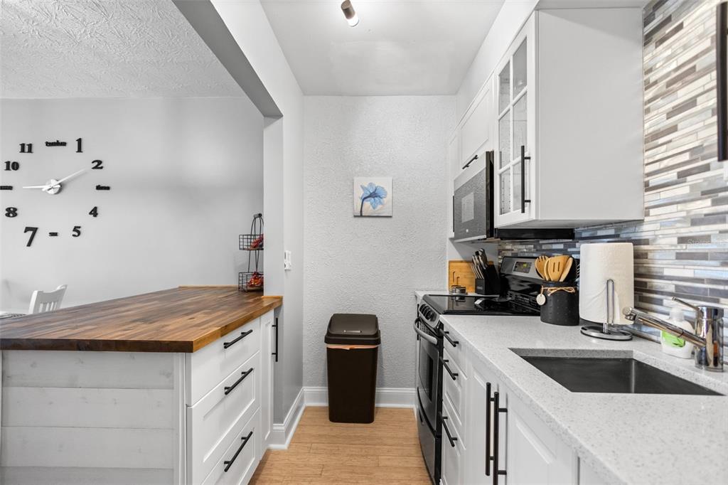 3443 Clark Road, Unit 242 Sarasota, FL 34231 - Photo 8 of 21 a kitchen with granite countertop a sink stove and cabinets