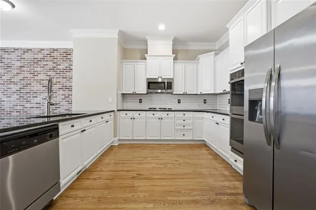 a large kitchen with stainless steel appliances cabinets a sink and a counter top space