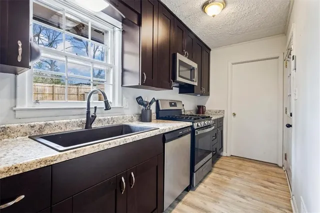 a kitchen with stainless steel appliances granite countertop a refrigerator stove and microwave