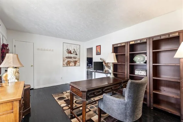 a living room with couches a flat screen tv and kitchen view