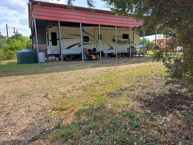 a view of house with outdoor seating and covered with green space