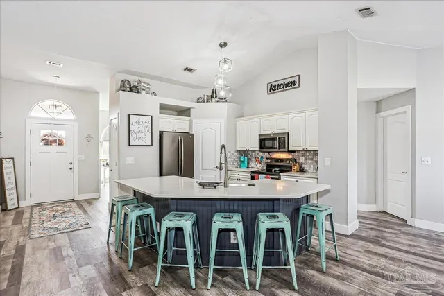 a kitchen with kitchen island a sink appliances and cabinets
