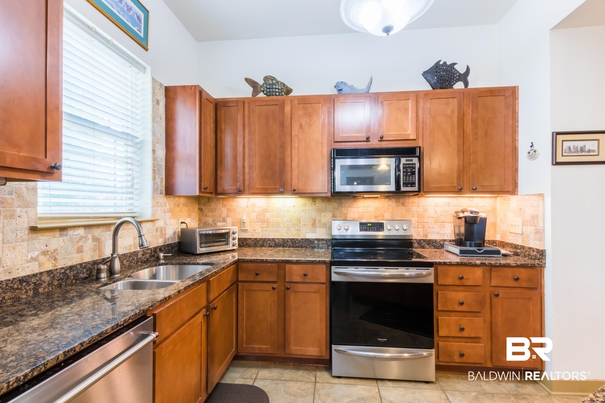 1430 Regency Road, Unit G103 Gulf Shores, AL 36542 - Photo 6 of 29 Kitchen featuring stainless steel appliances, backsplash, dark stone countertops, sink, and light tile floors