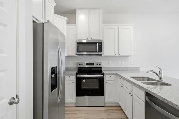 a kitchen with stainless steel appliances granite countertop a stove a refrigerator and a sink
