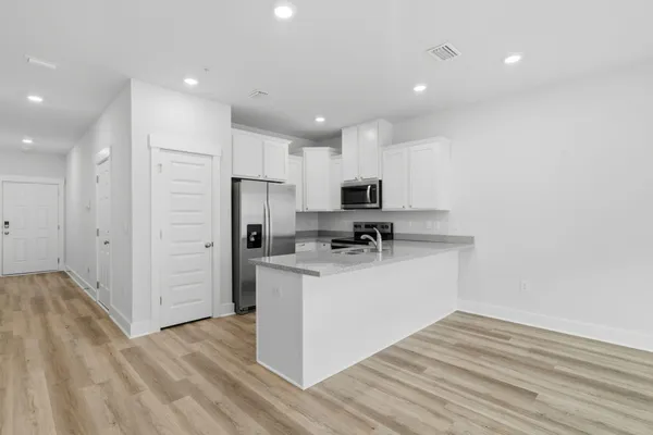 a kitchen with stainless steel appliances granite countertop a refrigerator and a stove top oven