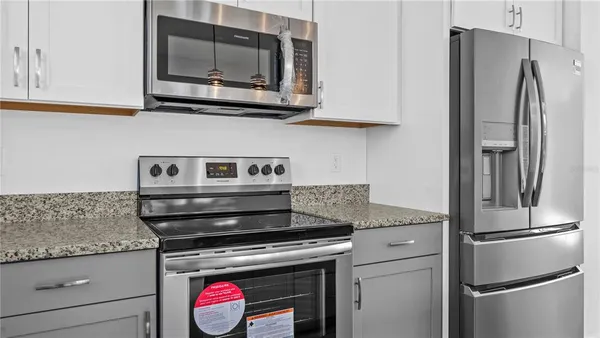 a kitchen with stainless steel appliances granite countertop a sink counter space cabinets and a stove