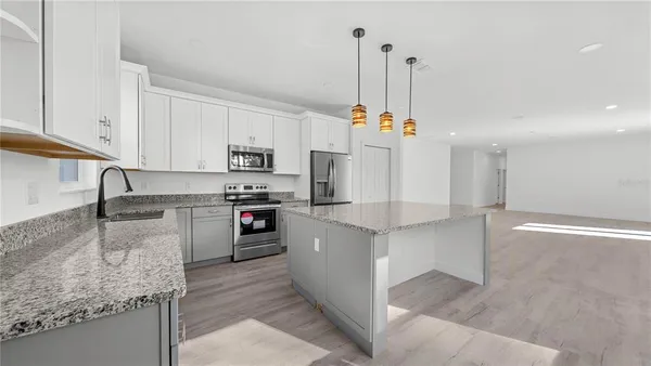 a kitchen with a sink a counter top space stainless steel appliances and cabinets