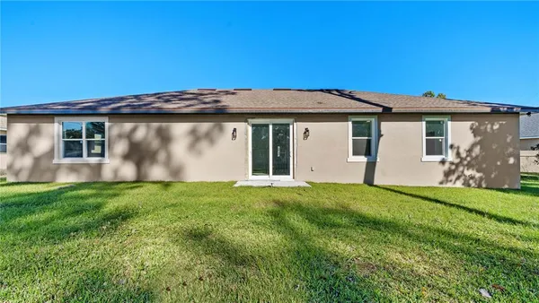 a view of backyard of house with green space