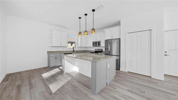 a kitchen with granite countertop a sink stove and refrigerator