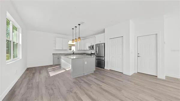 a bathroom with a granite countertop sink a toilet and a window