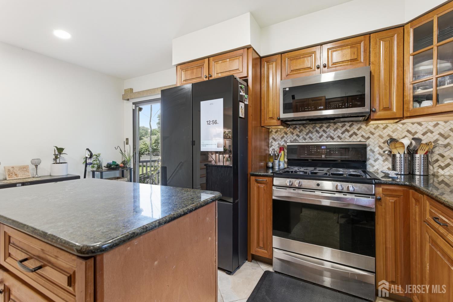 213 Normandy Road Edison, NJ 08820 - Photo 16 of 45 a kitchen with stainless steel appliances granite countertop a stove microwave and refrigerator