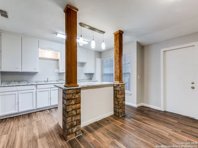 a kitchen with a refrigerator and white cabinets