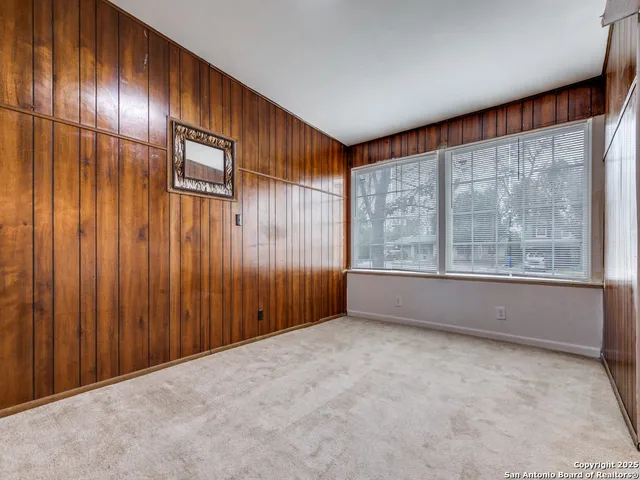 a spacious bathroom with a granite countertop sink a toilet a mirror and shower