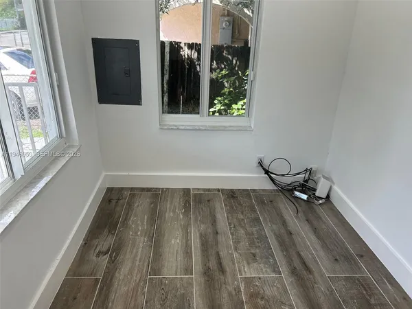 a view of an empty room with wooden floor