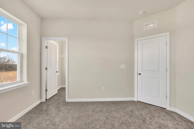 an empty room with windows and closet