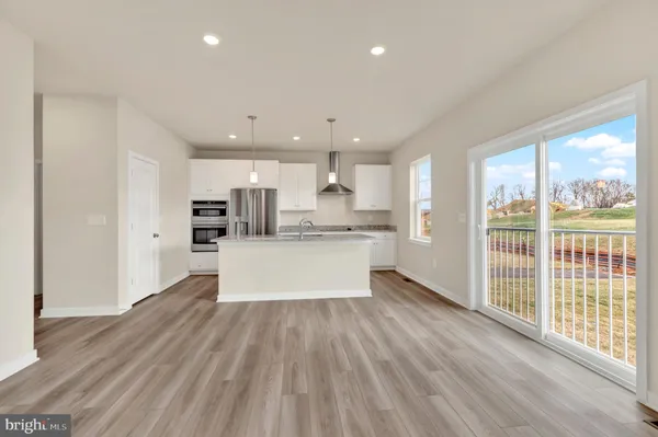 a large kitchen with large windows and wooden floor