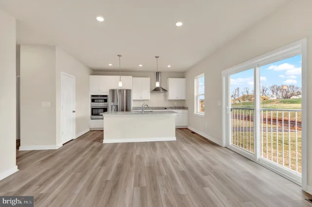 a large kitchen with large windows and wooden floor