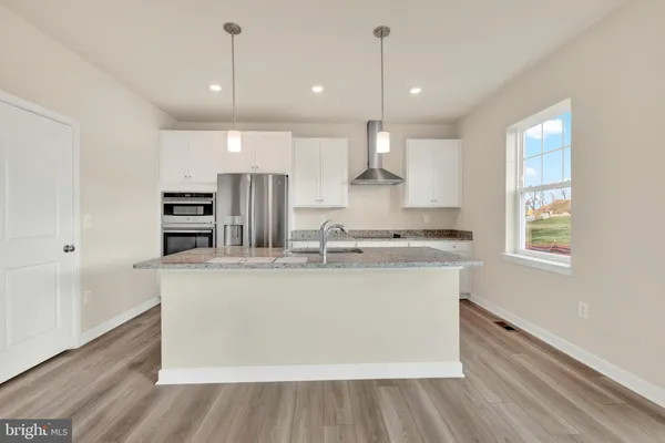 a large kitchen with kitchen island a stove a sink and a refrigerator
