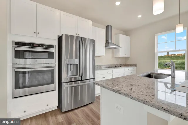 a kitchen with granite countertop a refrigerator stove and oven