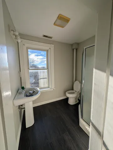 a bathroom with a sink toilet and a window