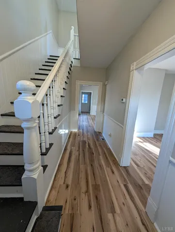 a view of entryway and hall with wooden floor