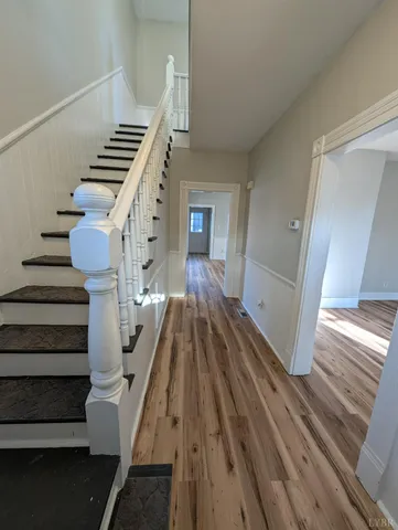 a view of entryway and hall with wooden floor
