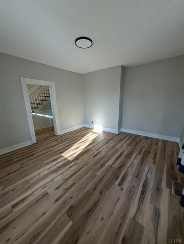 a view of empty room with wooden floor