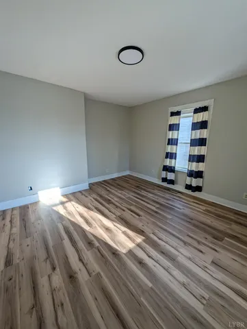 a view of a bedroom with wooden floor and cabinet
