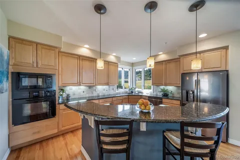 a kitchen with stainless steel appliances granite countertop a sink a stove and a refrigerator