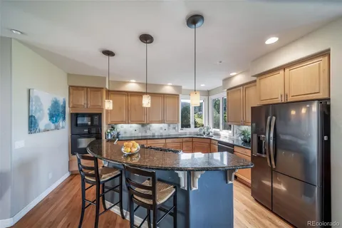 a kitchen with stainless steel appliances a dining table chairs refrigerator and fireplace