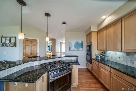 a kitchen with stainless steel appliances granite countertop a stove a sink and a refrigerator