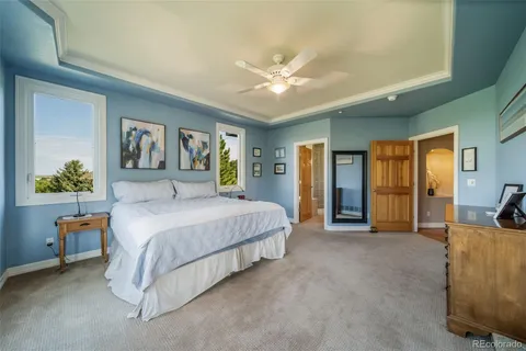 a spacious bedroom with a bed a couch and a chandelier