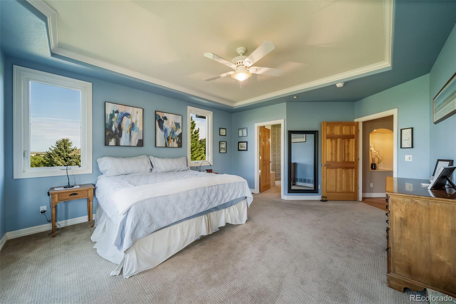 4612 High Spring Road Castle Rock, CO 80104 - Photo 28 of 50 a spacious bedroom with a bed a couch and a chandelier