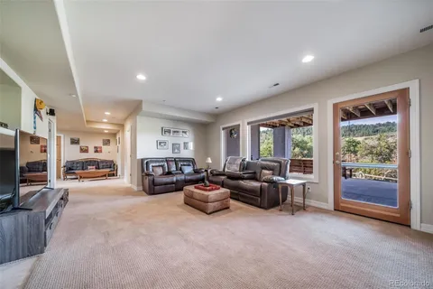 a living room with furniture large window and flat screen tv