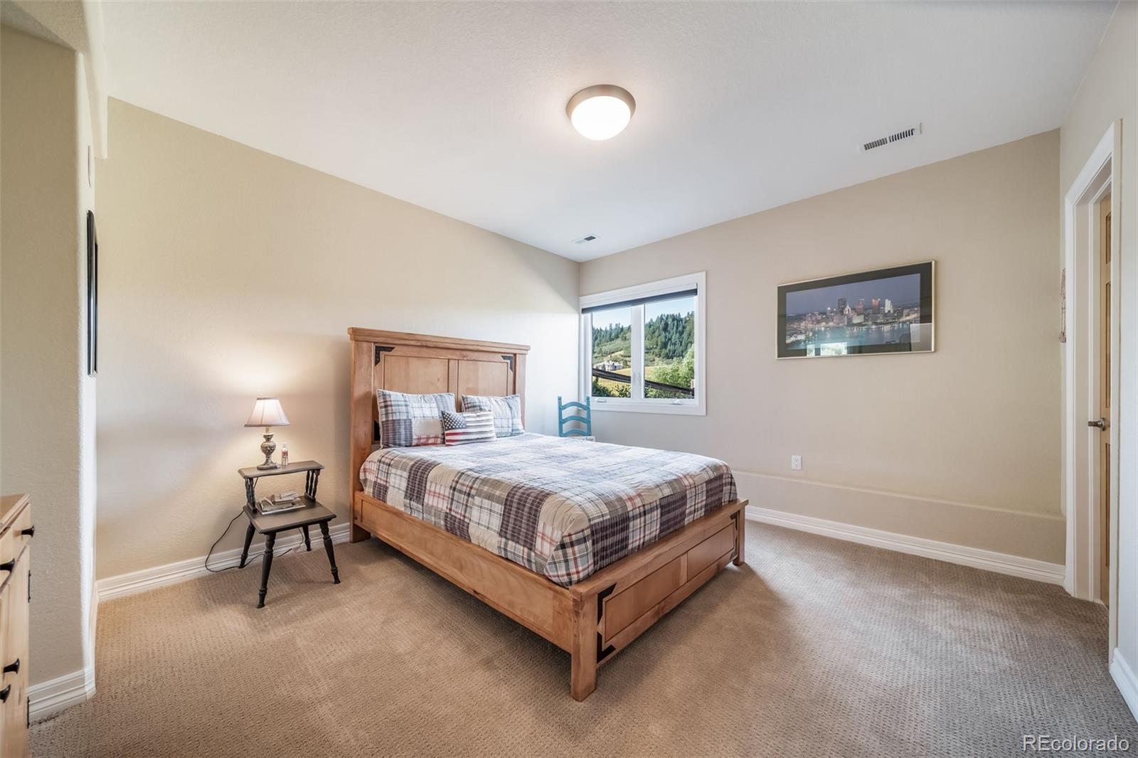 4612 High Spring Road Castle Rock, CO 80104 - Photo 40 of 50 a bed sitting in a bedroom next to a lamp