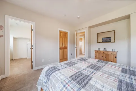 a bedroom with bed and paintings on the wall