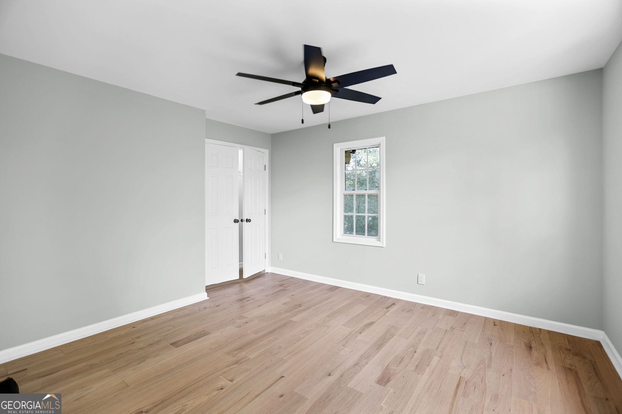 7060 Scenic Heights Road Manchester, GA 31816 - Photo 32 of 52 an empty room with wooden floor a ceiling fan and windows