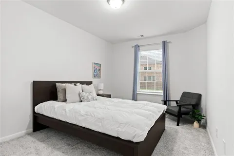 a bedroom with a bed a table and a chair