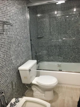 a white toilet sitting next to a bathroom sink