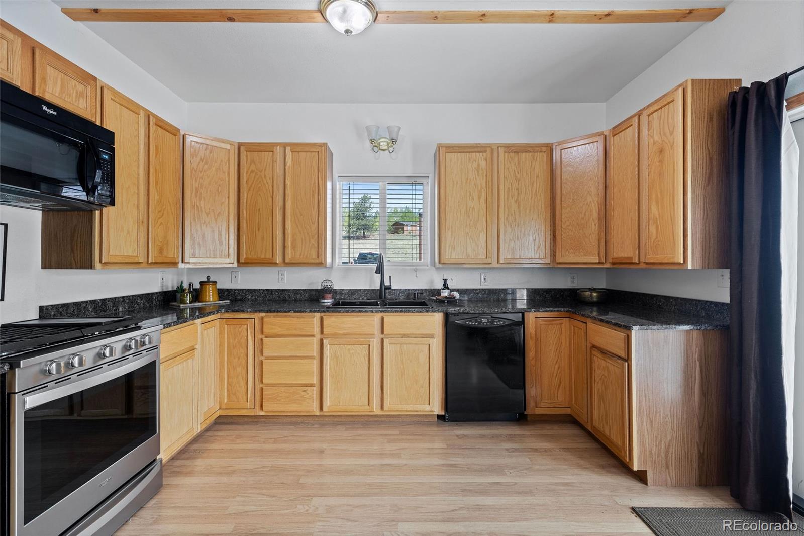 7551 Remington Road Como, CO 80432 - Photo 11 of 35 a kitchen with stainless steel appliances granite countertop a stove a sink and a microwave