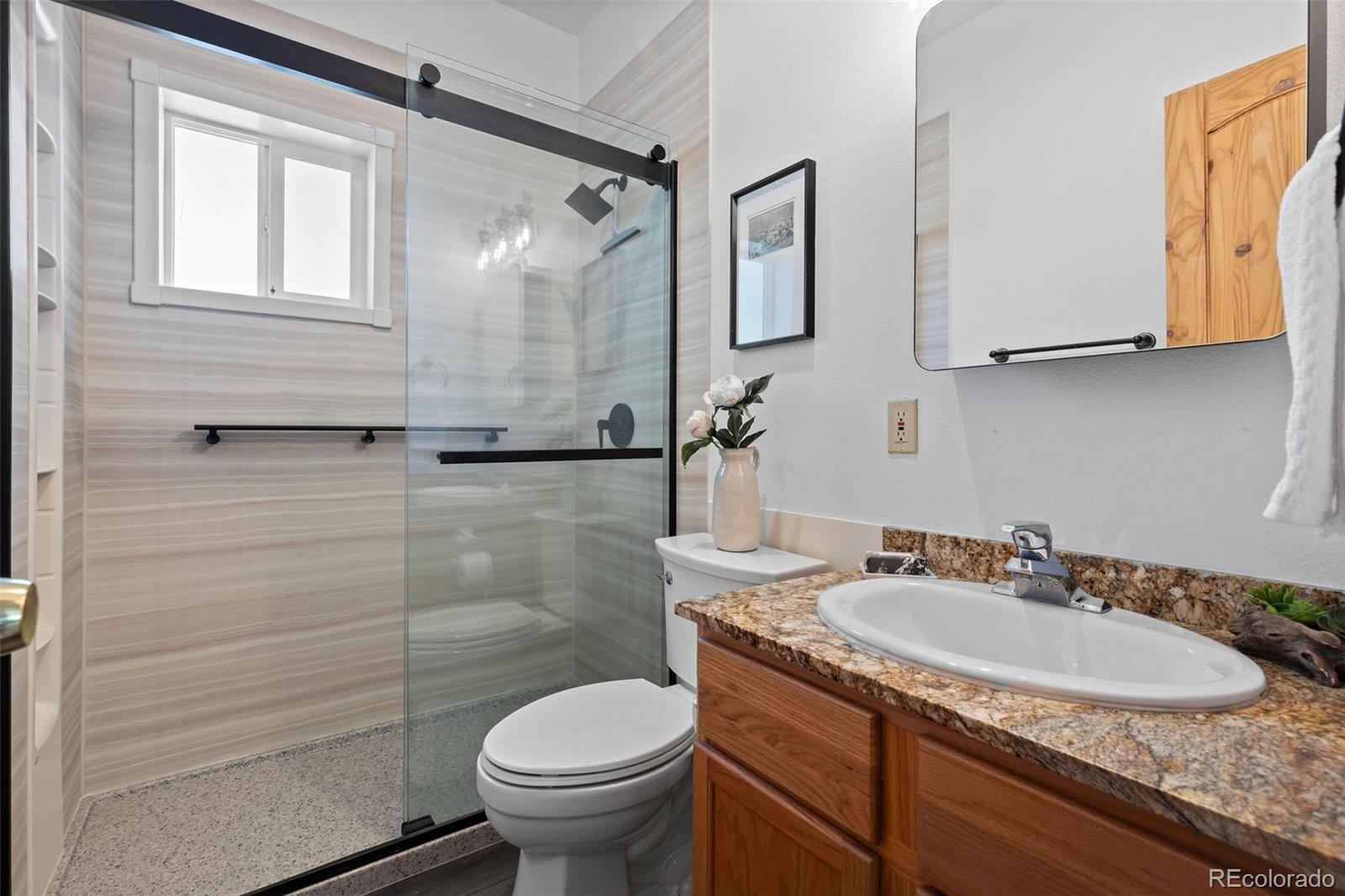 7551 Remington Road Como, CO 80432 - Photo 19 of 35 a bathroom with a granite countertop toilet sink and mirror