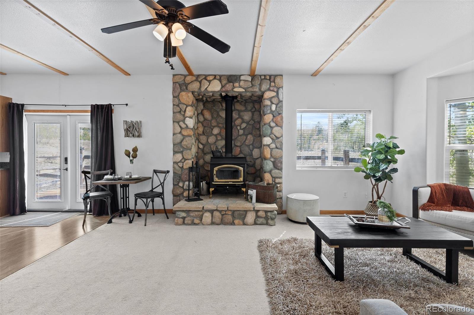 7551 Remington Road Como, CO 80432 - Photo 7 of 35 a living room with furniture a chandelier and a fireplace