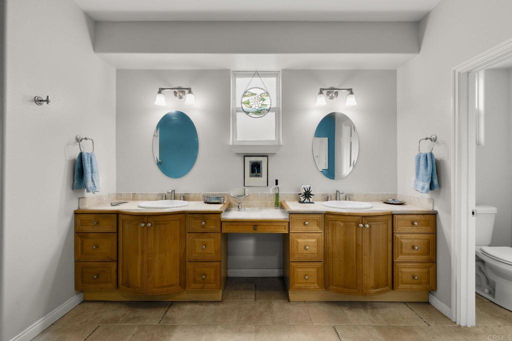 1402 Rimrock Drive Escondido, CA 92027 - Photo 36 of 69 a bathroom with a double vanity sink and a mirror