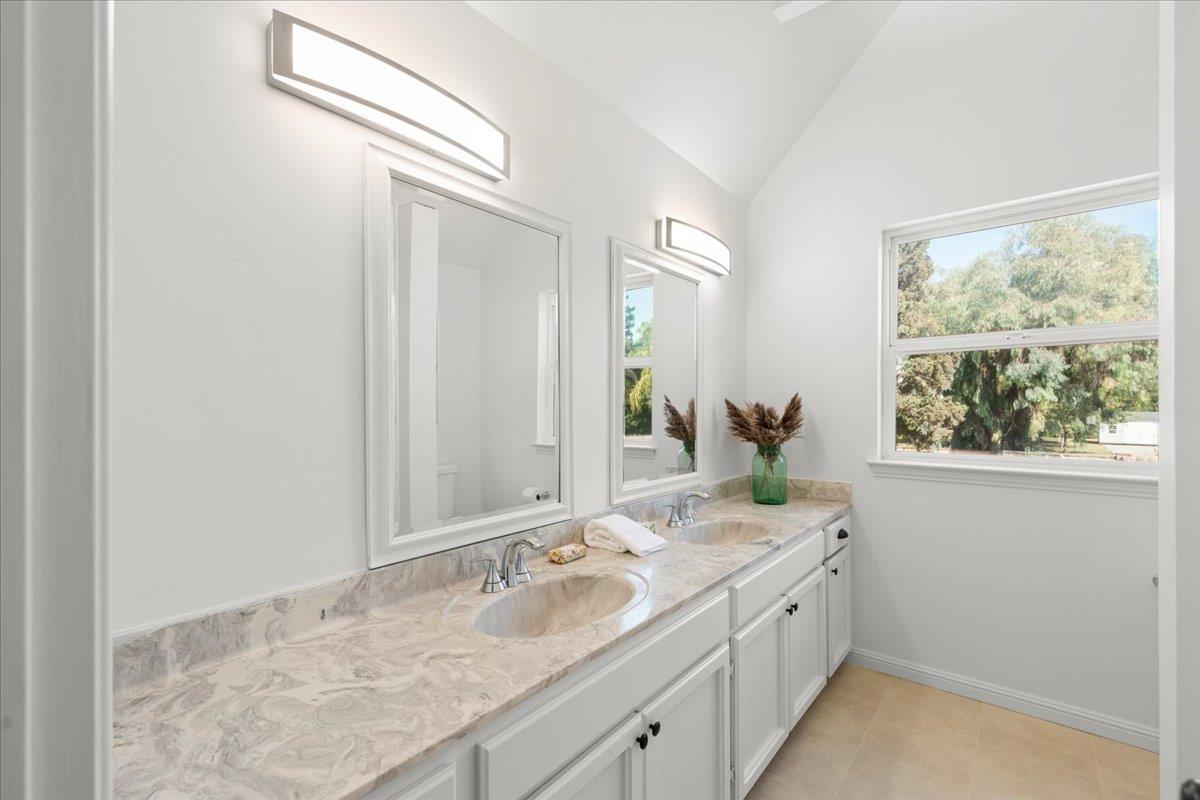 3306 Leavesley Road Gilroy, CA 95020 - Photo 41 of 60 a bathroom with a granite countertop sink a large mirror and a window