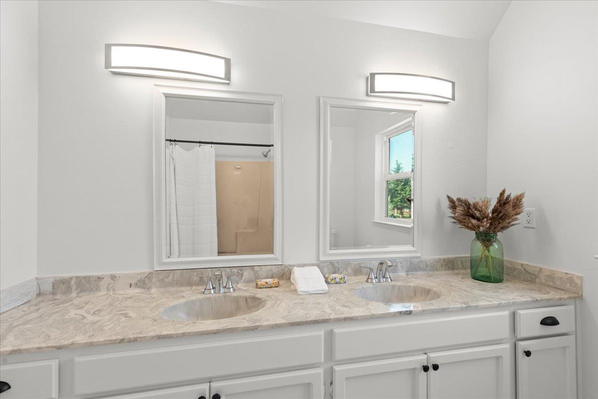 3306 Leavesley Road Gilroy, CA 95020 - Photo 42 of 60 a bathroom with a granite countertop sink and a mirror
