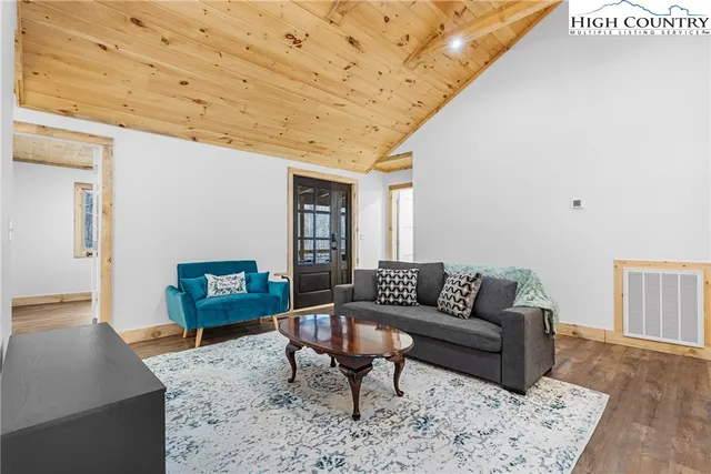 a living room with furniture a rug and a wooden floor